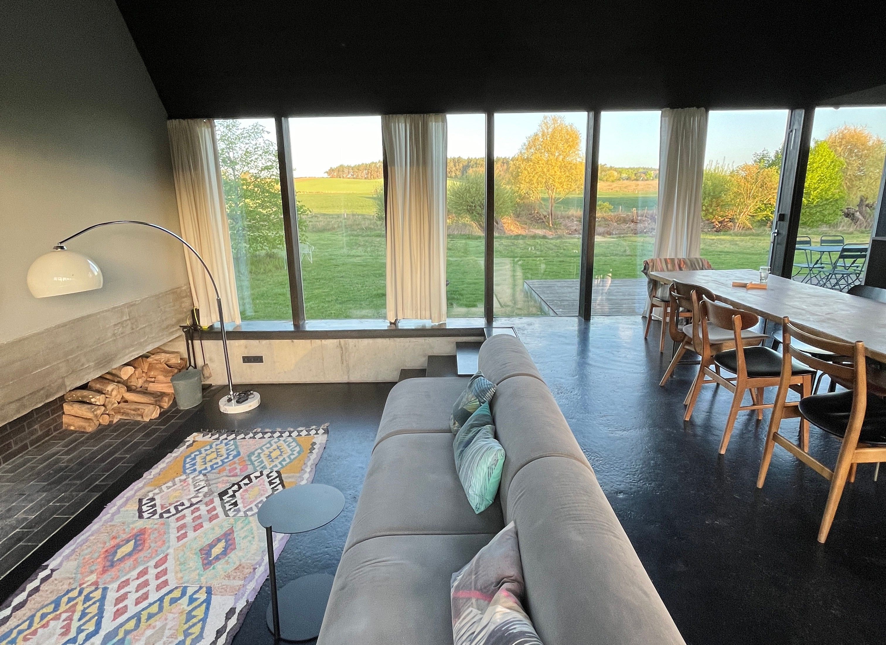 Ein modernes Wohnzimmer mit einer Couch, einem Esstisch und einem Kamin.