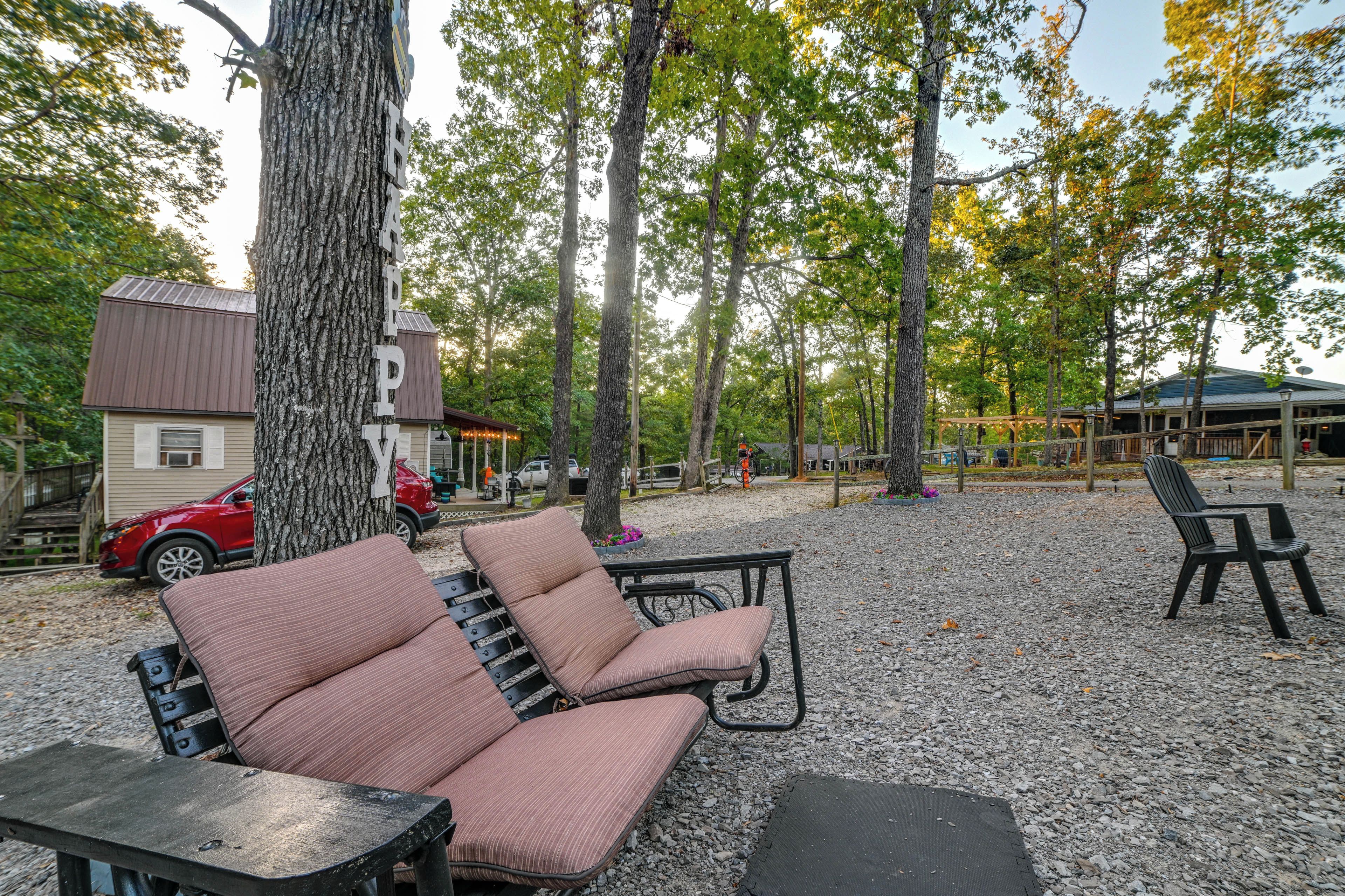 A park with a bench, a swing, and a covered picnic area.
