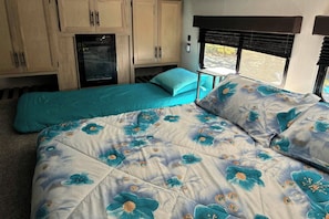 A bedroom with a bed, a small table, and a window with blinds. - 1 Mi to Kentucky Lake! 'Special Place' Tiny Home (Springville)