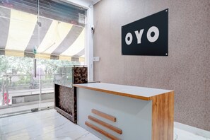 Una mesa de recepción con un letrero que dice 'OYO' en la pared.