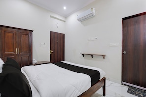 Een hotelkamer met een bed, kledingkast en ingebouwde airconditioning.