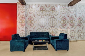 Una habitación con un conjunto de sofás, una mesa de centro y una pared de acento roja.