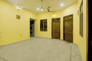 Un pasillo con dos puertas, un ventilador de techo y una lámpara.