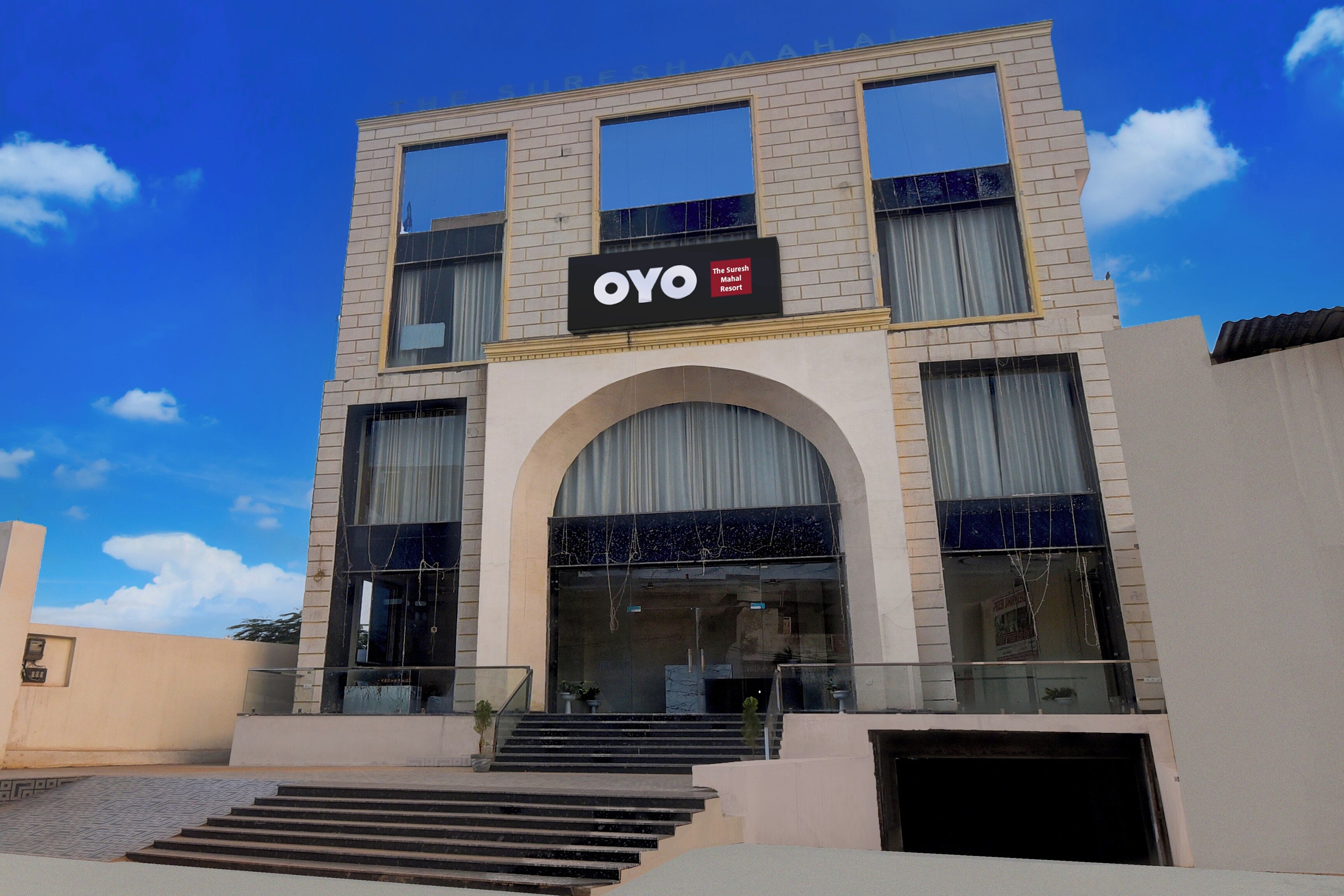 Un hotel con un cartel llamativo que reza 'OYO The Suresh Mahal Resort'.