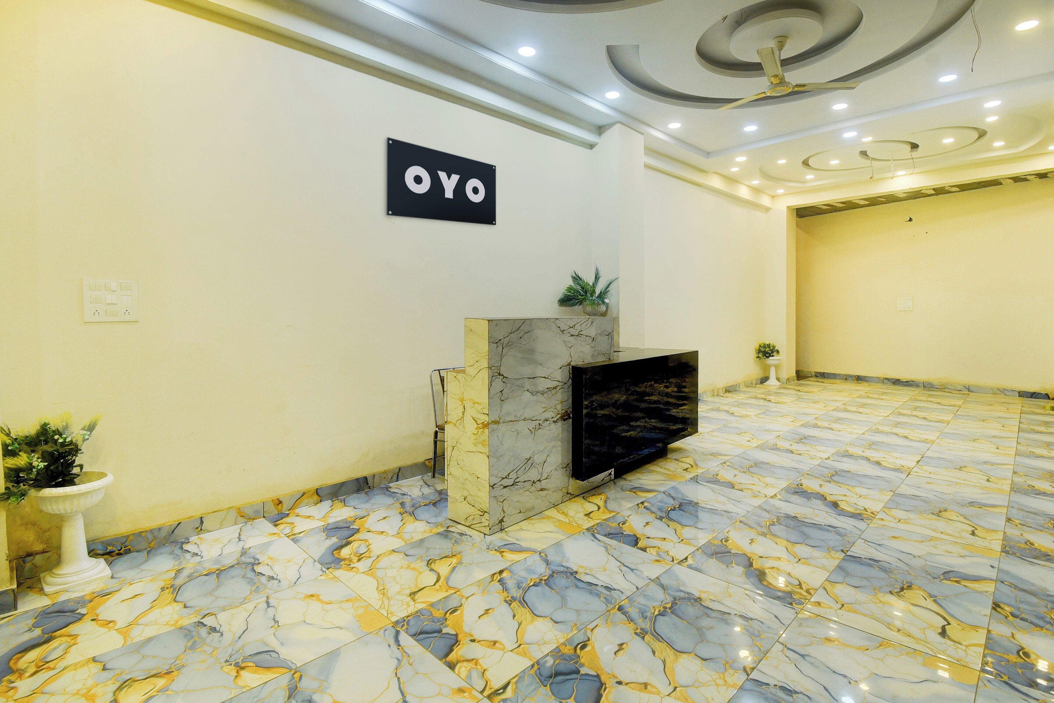Un vestíbulo amplio con piso de mármol, una mesa de recepción y un cartel que dice 'OYO'.