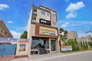 A hotel with a signboard for OYO and another for Queen's Academy Sr. Sec. School. - Hotel O Sanraj Hotel (Jaipur)