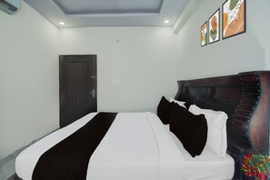 Ein Hotelzimmer mit einem Bett, einer Tür und Wandbildern.