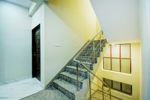 Eine Treppe mit Handlauf, einer Tür und einem Fenster mit Blick ins Freie.