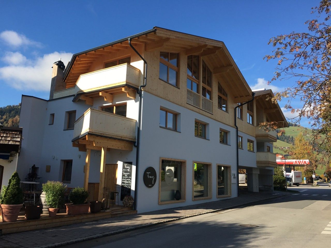 A two-story building with a balcony, large windows, and a sign indicating a restaurant.