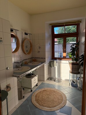Ein Badezimmer mit Waschbecken, Spiegel und einem Fenster mit Aussicht.