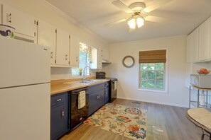 A kitchen with white cabinets, a wooden countertop, a ceiling fan, and a window with a view of greenery. - 30-Acre Retreat w/ Mtn Views! 2 Mi to Cherokee (Tellico Plains)