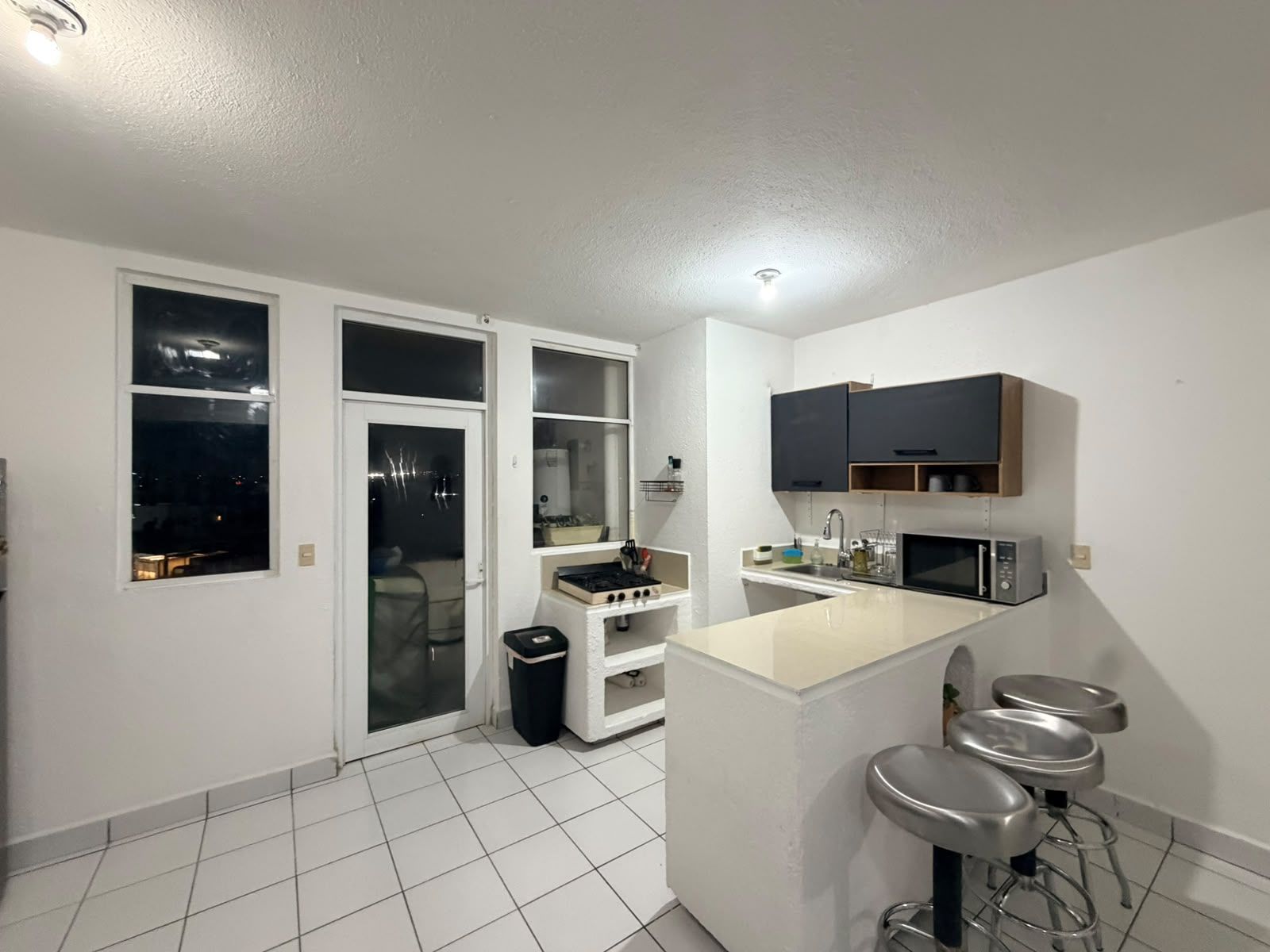 A modern kitchen with a central island, a microwave, and a sink.