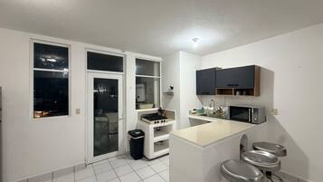 A modern kitchen with a central island, a microwave, and a sink.