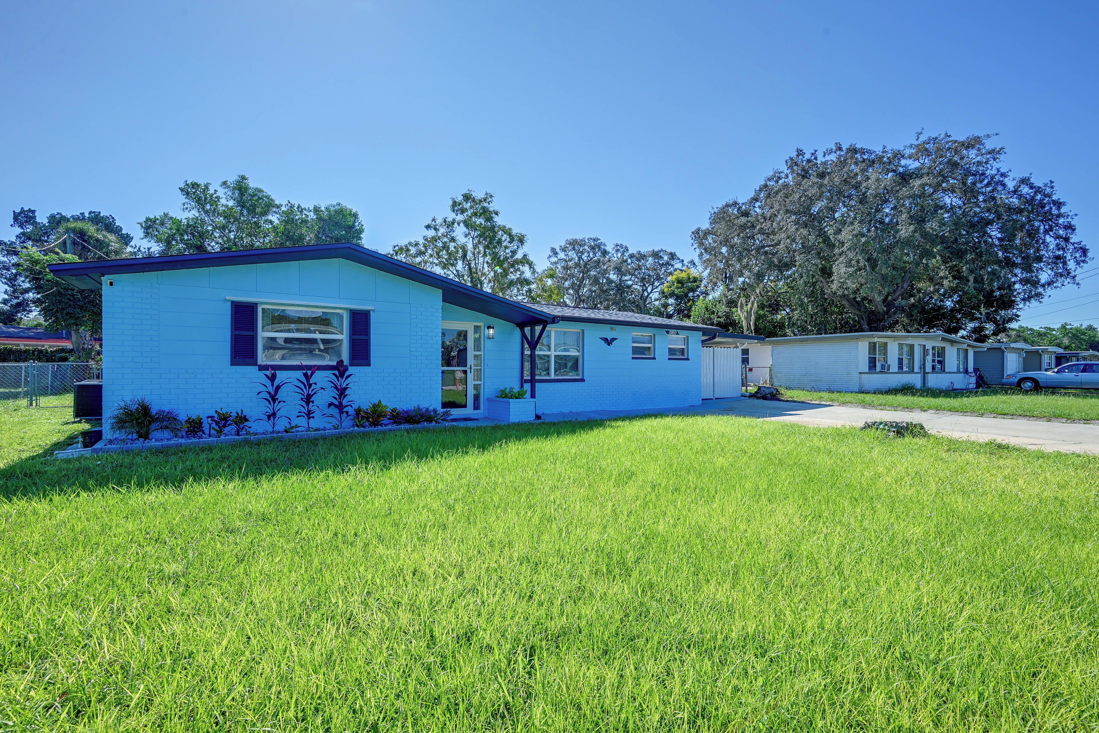 A single-story mobile home with a blue exterior and a small front yard.