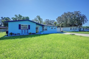 Ein eingeschossiges Mobilheim mit blauer Fassade und kleinem Vorgarten.