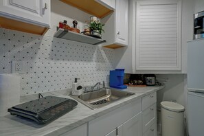 Uma cozinha moderna com forno embutido, pia e cafeteira.