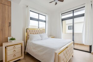 A bedroom with a bed, bedside tables, a wardrobe, and large windows. - Beautiful place 12 minutes from airport (Punta Cana)