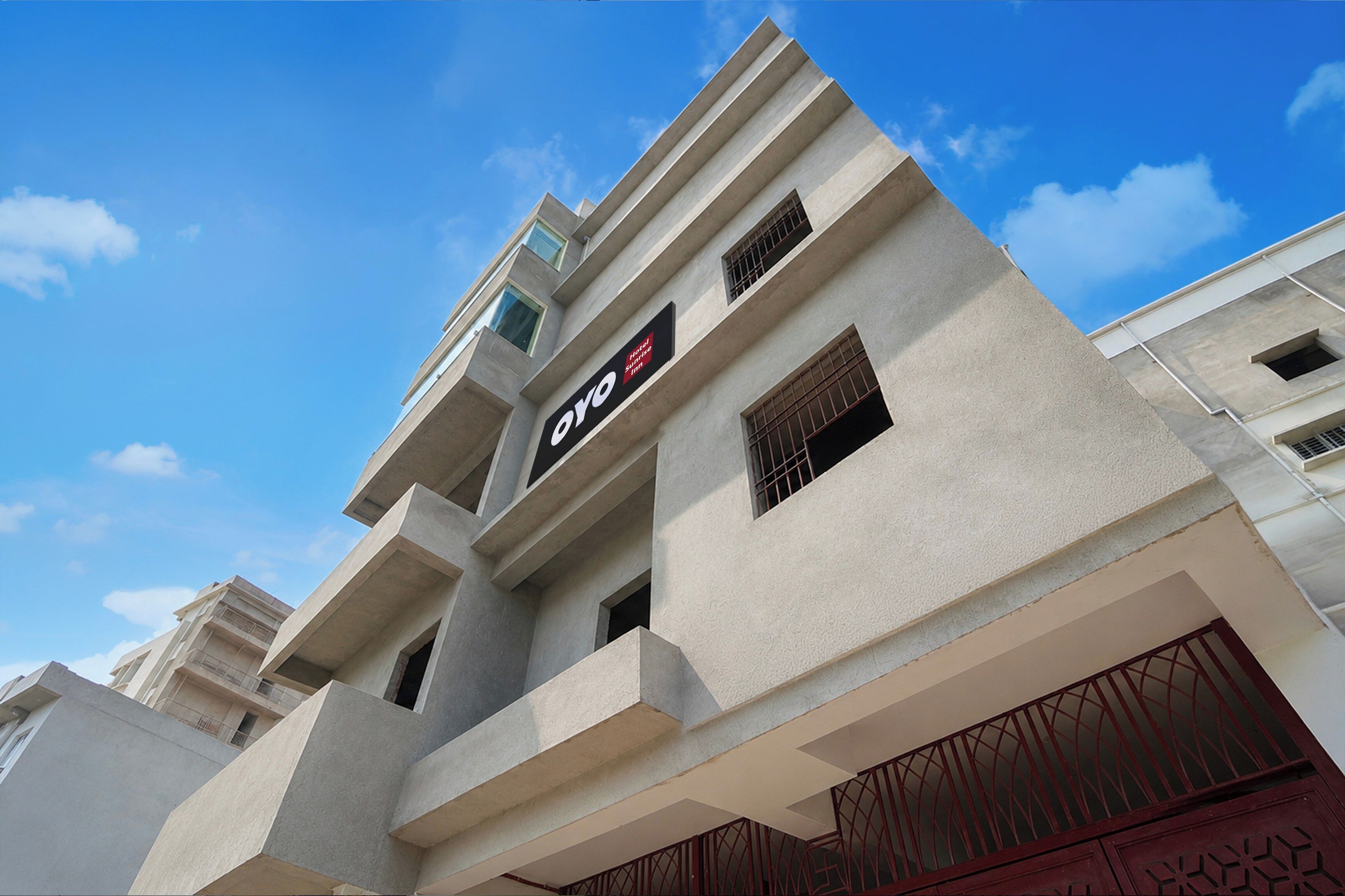 A hotel building with a modern design, featuring a prominent sign for the 'Oyo Hotel Suite Inn.'