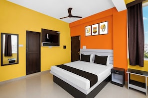 A hotel room with a bed, a television, a ceiling fan, and artwork on the wall. - HOTEL O SUNRISE INN (Danapur)