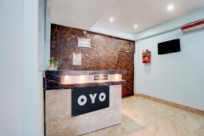 Mostrador de recepción con fondo de madera y encimera de mármol.