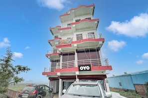 Un immeuble hôtelier à plusieurs étages, doté de balcons et d’une enseigne indiquant qu’il s’agit d’un hôtel et d’un restaurant.