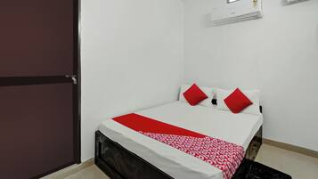 Un dormitorio con cama, ventana y equipo de aire acondicionado.