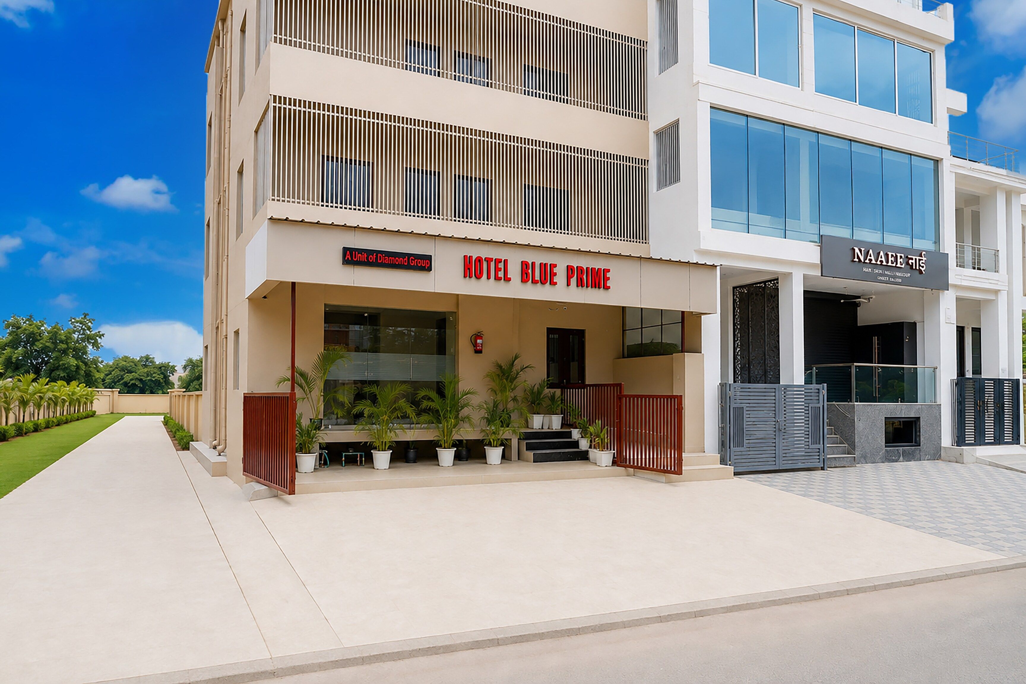 A modern hotel with a prominent sign for 'HOTEL BLUE PRIME' and a unit of the 'Diamond Group.'