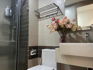 A bathroom with a glass shower enclosure, a toilet, a sink, and a towel rack. - RiverGate Suite – Upscale Apartment Near Ben Thanh Market (Thành phố Hồ Chí Minh)