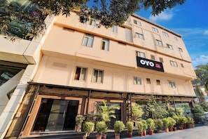 Ein Hotelgebäude mit vielen Fenstern und einem Schild für 'OYO Hotel Ganpati'.