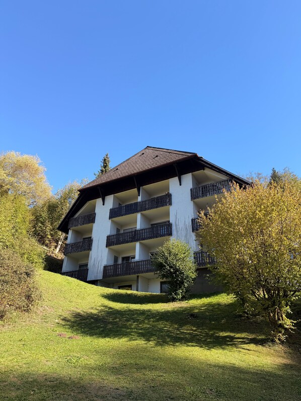 A multi-story building with balconies, surrounded by greenery and trees. - Modern 2-Room Holiday Apartments Triberg (Triberg im Schwarzwald)
