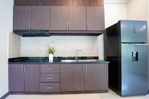 A modern kitchen with dark wood cabinets, a stainless steel refrigerator, and a black countertop. - Perfect Family 3BR Villa with Private Pool Rawai (Tambon Rawai)