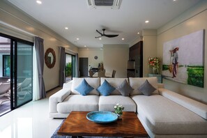 A modern living room with a sectional sofa, a coffee table, and a painting on the wall. - Perfect Family 3BR Villa with Private Pool Rawai (Tambon Rawai)