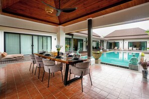 A dining area with a pool view, wooden ceiling, and modern furniture. - Perfect Family 3BR Villa with Private Pool Rawai (Tambon Rawai)