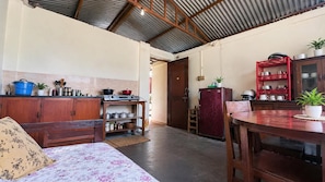 A compact kitchen with a dining area, a refrigerator, and a stove. - Charming 3-bedroom house in Suryabinayak perfect for your stay (Suryabinayak)