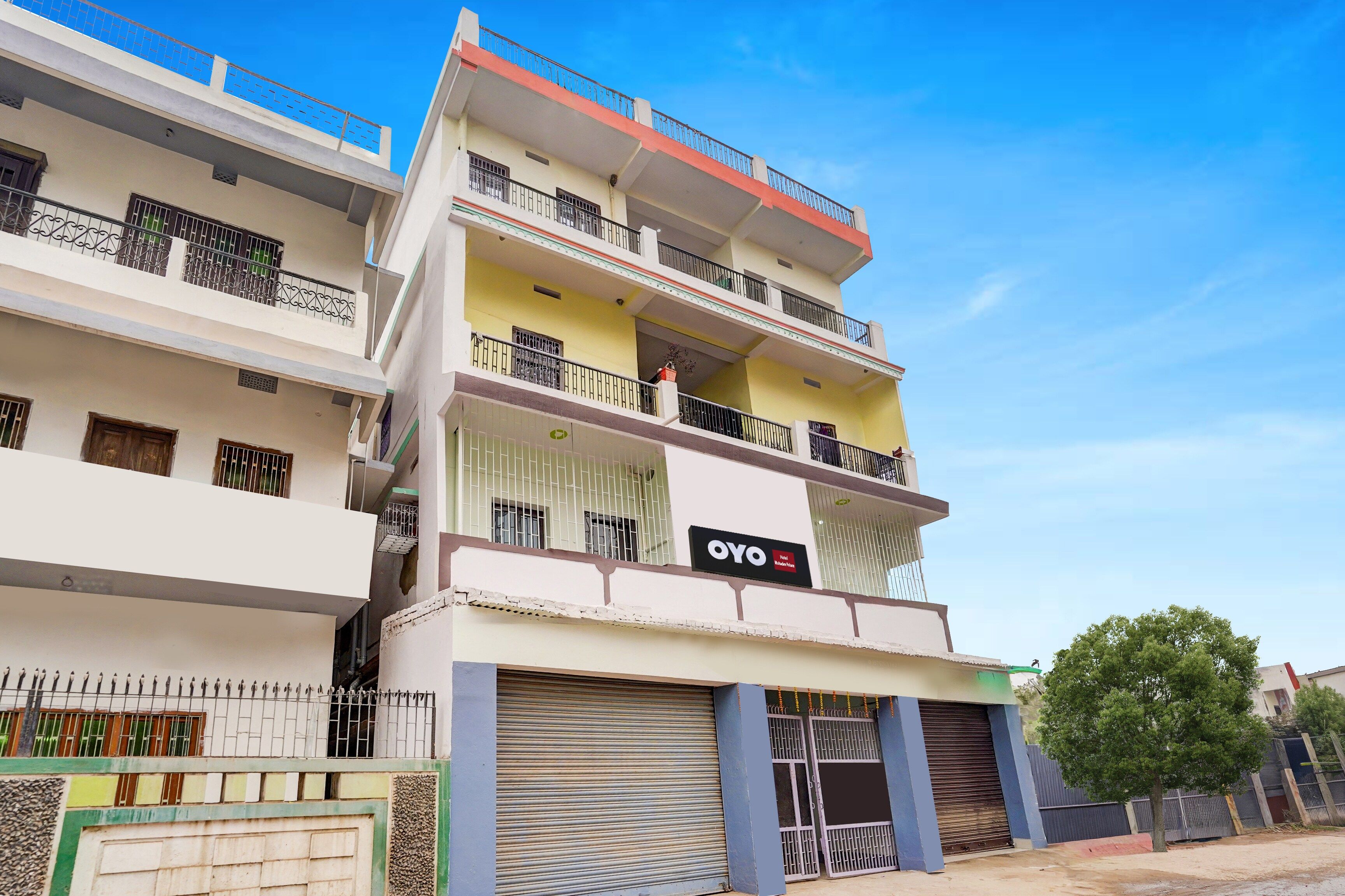 Un immeuble à plusieurs étages doté de balcons, d’une devanture visible et d’une entrée fermée par un portail.