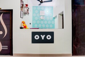 Una habitación con un reloj, un ventilador de techo y un letrero que dice 'OYO'.