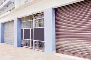 A building with closed metal gates and a closed roller shutter door. - Hotel O Mahadev Palace (Patna)
