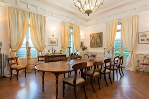 A formal dining room with a large wooden table, multiple chairs, and classic decor. - Château De Bézyl - Manon Room with pool access in high season (Sixt-sur-Aff)