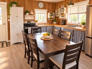 A kitchen with a wooden interior, white cabinetry, a dining table with chairs, and a built-in bench.