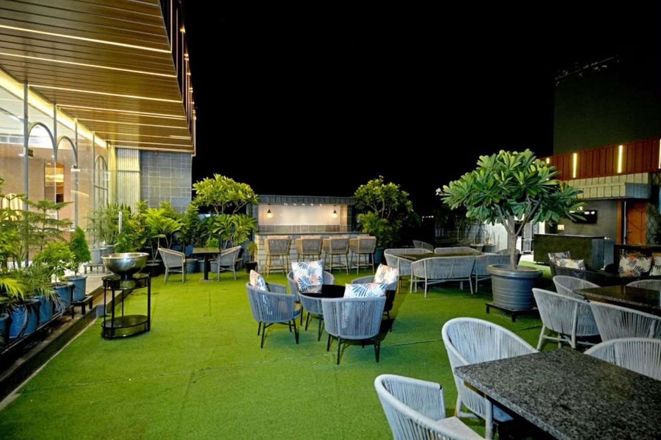 An outdoor patio area with seating arrangements and potted plants.