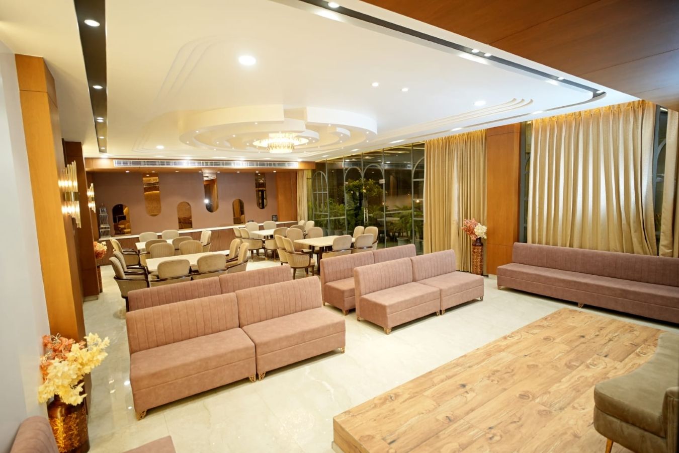 A hotel lobby with seating areas, a reception desk, and a large window.