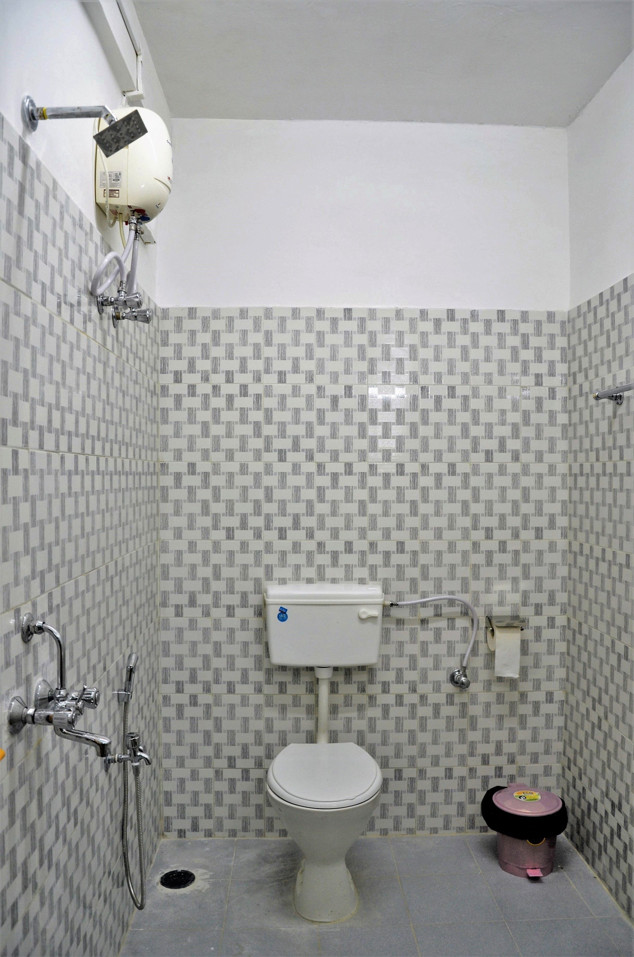 A bathroom with a toilet, a shower, and a bidet.