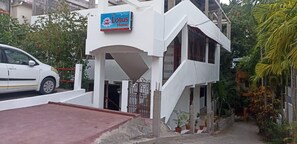 A white two-story building with a sign reading 'The Lotus Home.' - The Lotus Home (Sri Vijaya Puram)
