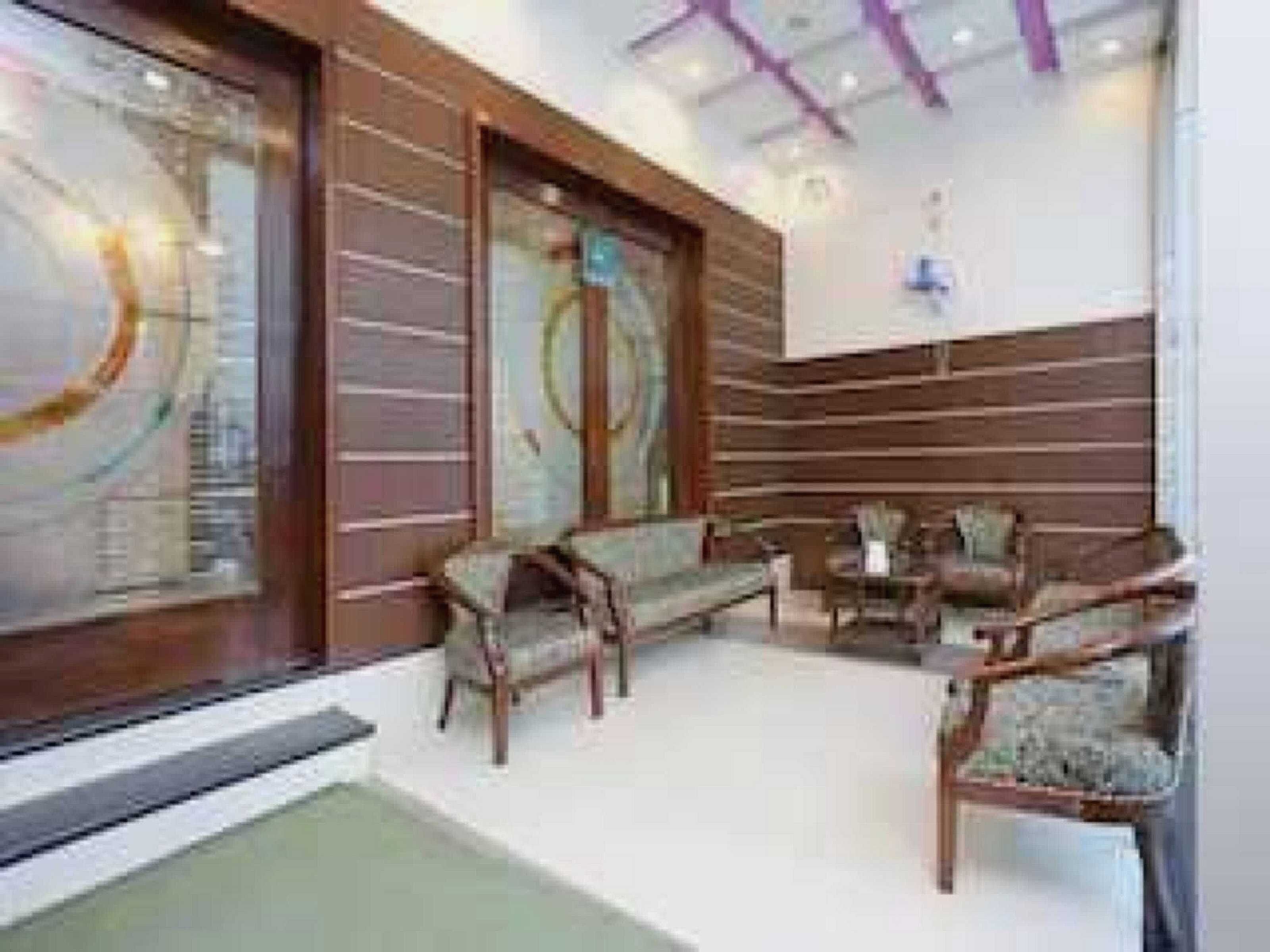 A modern interior with a seating area, a large window, and a wall with a geometric design.