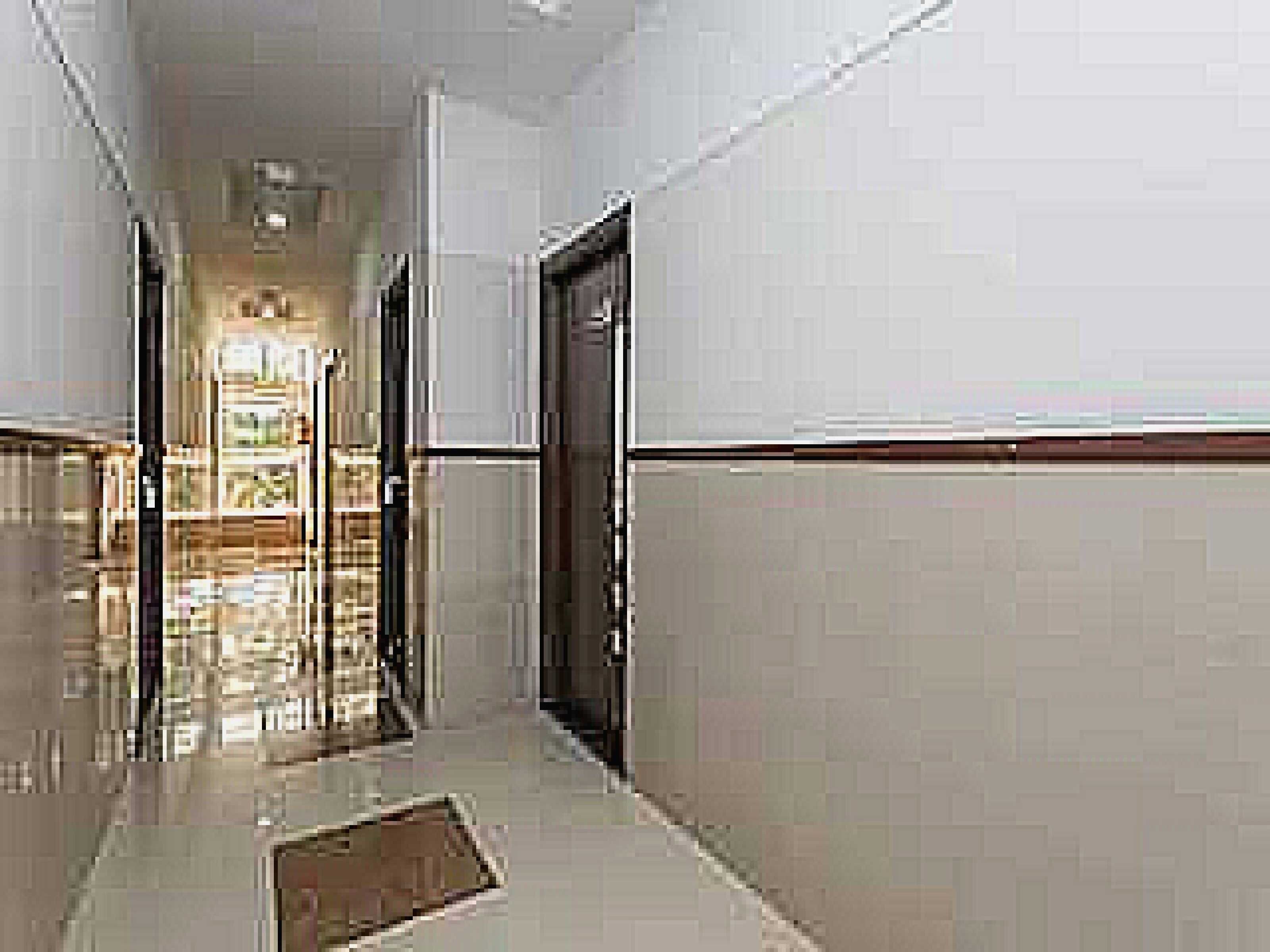A corridor with a shiny floor, a door on the right, and a light source at the end.