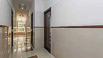 A corridor with a shiny floor, a door on the right, and a light source at the end.