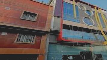 A multi-story building with a red facade and a blue upper section.