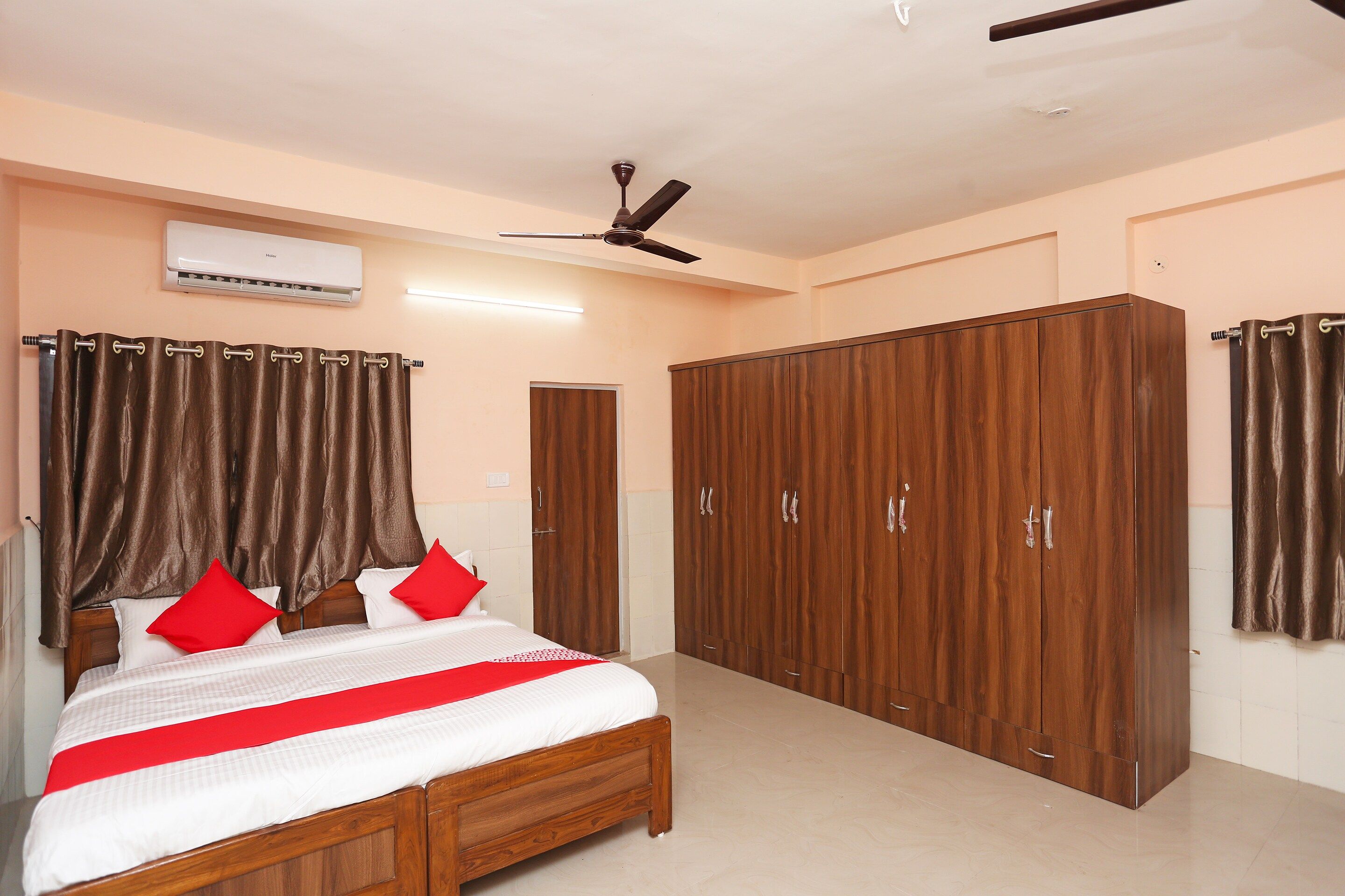 Ein Schlafzimmer mit Bett, Kleiderschrank und Deckenventilator.