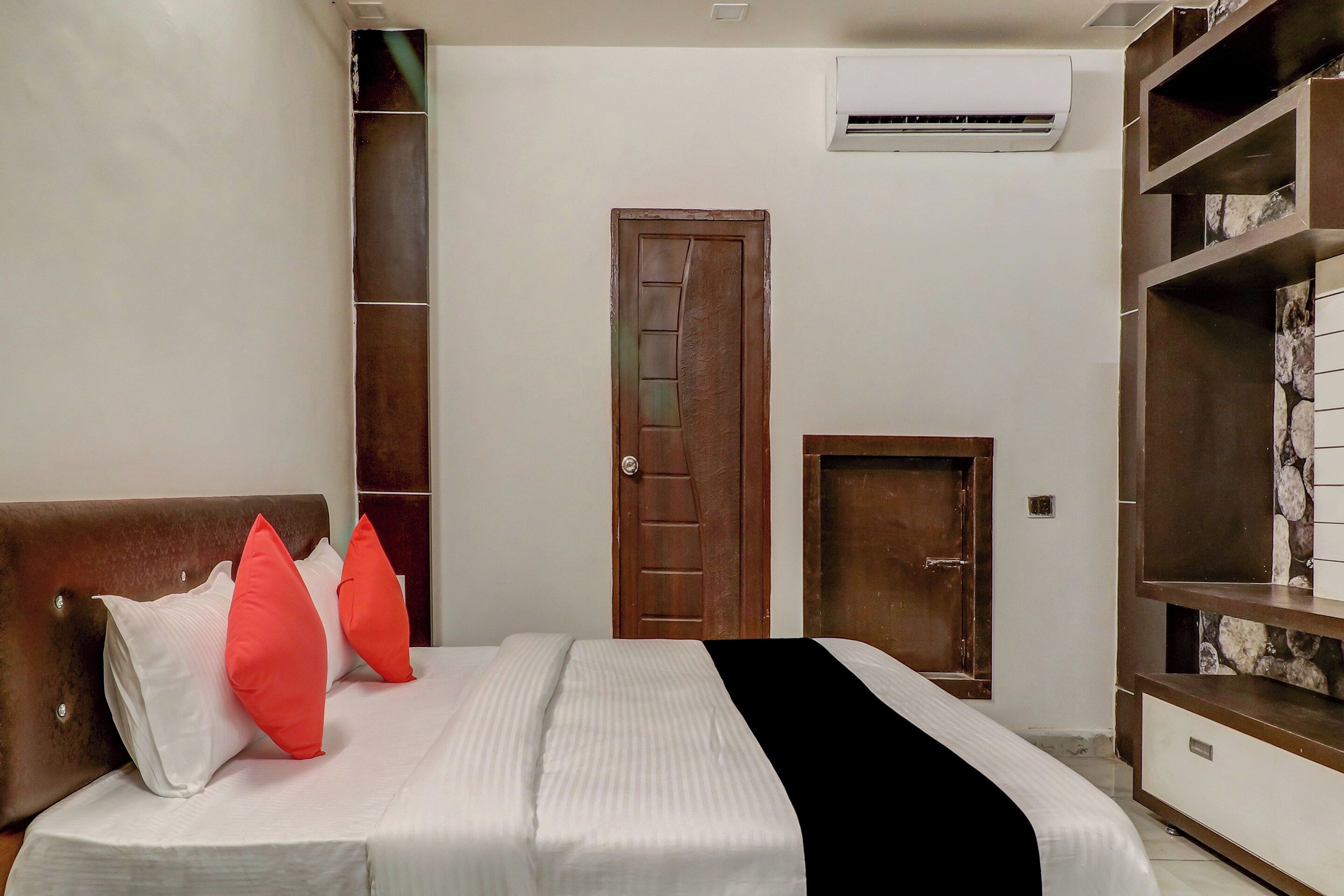 Ein Schlafzimmer mit einem Bett, einem Kleiderschrank, einer Tür und einer Klimaanlage.