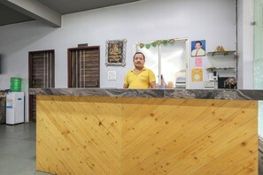Una recepción con detalles de madera, una cocina con dos puertas y una pared decorada con motivos religiosos.